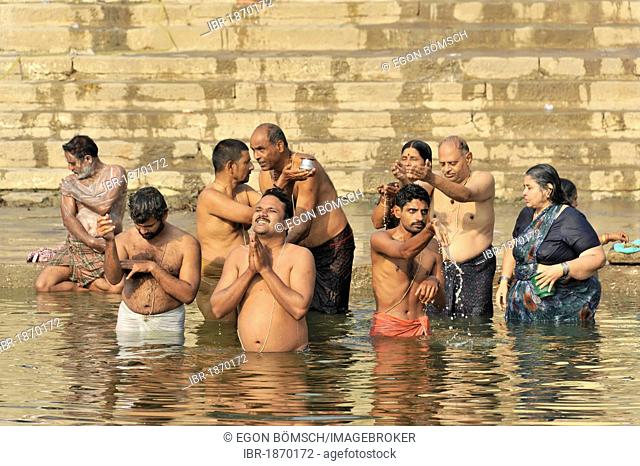 Believers on the ghats or steps on the banks of the Ganges river in ritual ablutions, Varanasi, Benares, Uttar Pradesh, India, South Asia