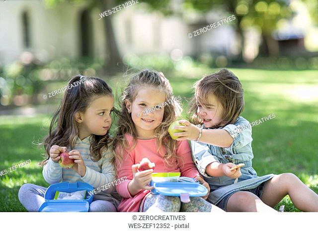 Girls in garden sharing lunch