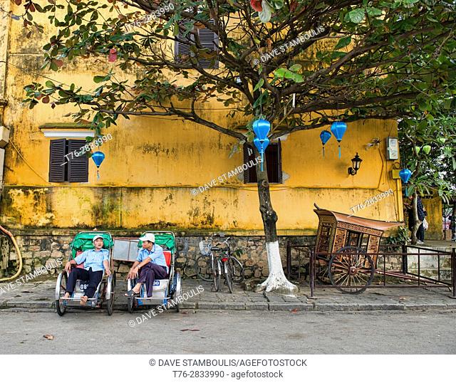 Cyclo drivers relaxing in the picturesque old town of Hoi An, Vietnam