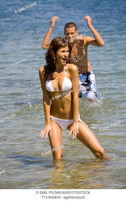 Young couple is playing in water