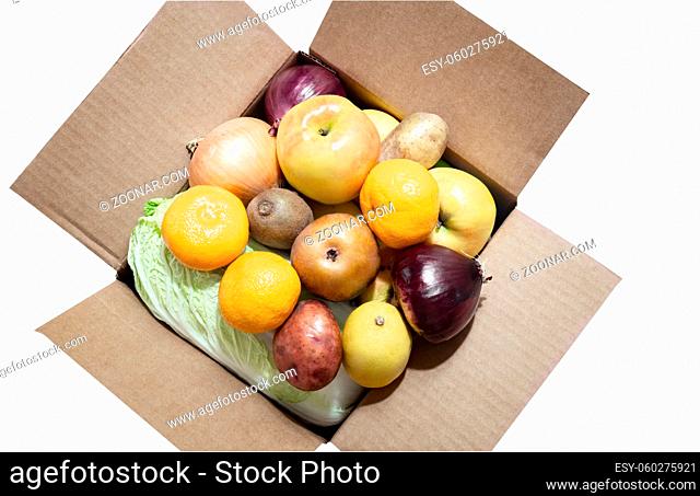 The cardboard box contains a variety of fruits and vegetables. Eco-friendly packaging. Food delivery during the coronavirus pandemic