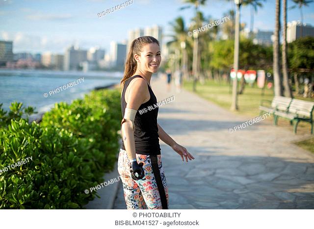 Atleta amputado de raza mixta caminando en el paseo marítimo urbano