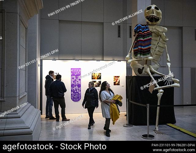 01 November 2023, Berlin: A skeleton figure sits on a pedestal in the Humboldt Forum. During the festival, the dead return from the afterlife to the realm of...