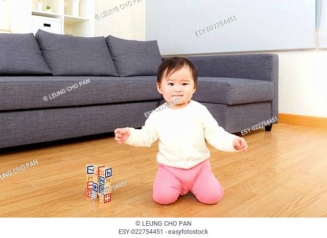 Asian baby girl play toy block at home