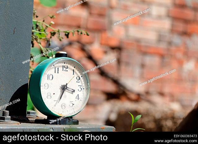 Retro alarm clock on table on brick wall background
