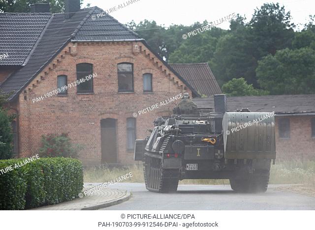 03 July 2019, Mecklenburg-Western Pomerania, Trebs: A Bundeswehr chain mail tank drives through the village of Trebs. The situation in the forest fire area on a...