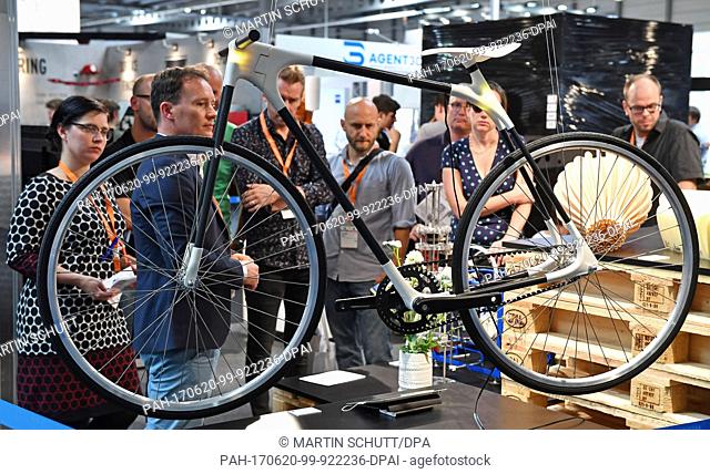 Jury members look at a the bicycle frame 'Frame One', whose connecting points were 3D-printed, at the trade fair 'Rapid.Tech und FabCon 3