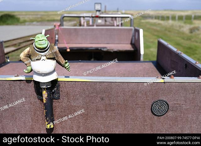 29 July 2020, Schleswig-Holstein, Langeneß: The mythical creature Shrek is attached to a tipper truck. The Dagebüll-Oland-Langeneß Hallig railway is a field...