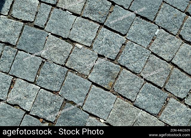 grunge cobblestone tile road abstract background closeup and cigarette butts stubs on it