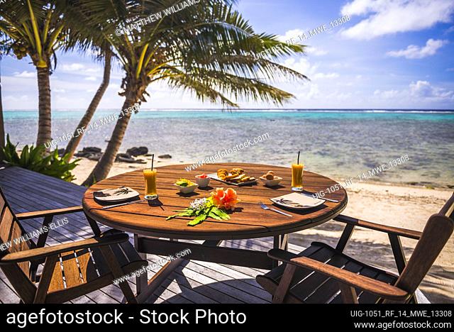 Luxury Villa accommodation with sea views of the tropical Pacific ocean and palm trees with breakfast table set up at the hotel, Muri, Rarotonga, Cook Islands