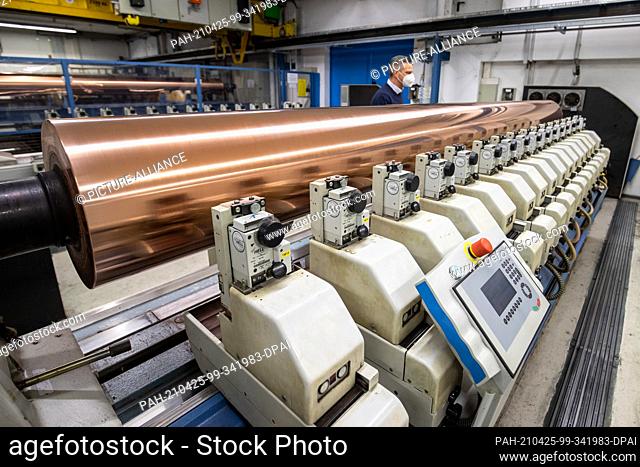 PRODUCTION - 19 April 2021, Bavaria, Nuremberg: A copper-plated gravure cylinder lies on an engraving machine at the Prinovis printing plant