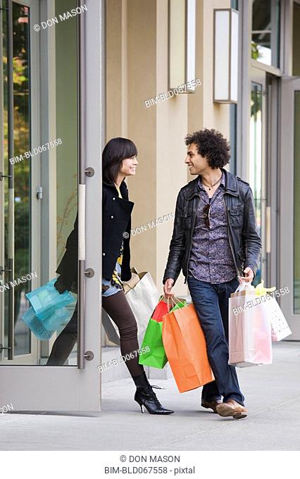 Couple leaving store with shopping bags