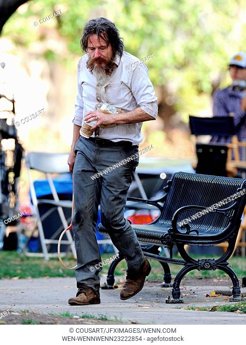 Bryan Cranston looks homeless and unrecognizable in dirty clothes and thick mustache as he sits lonely in a park bench begging for food for his new movie...