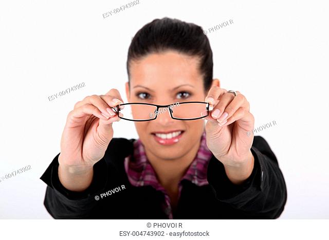 Woman holding her glasses away from her face