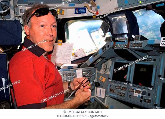 Astronaut Dominic Gorie, STS-123 commander, works at the commander's station on the flight deck of Space Shuttle Endeavour while docked with the International...