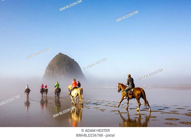 People horseback riding on beach