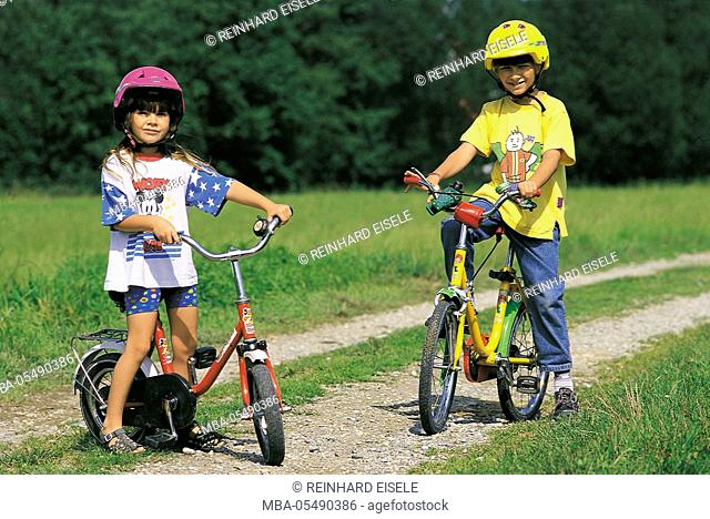 Two children by bicycle on a country lane