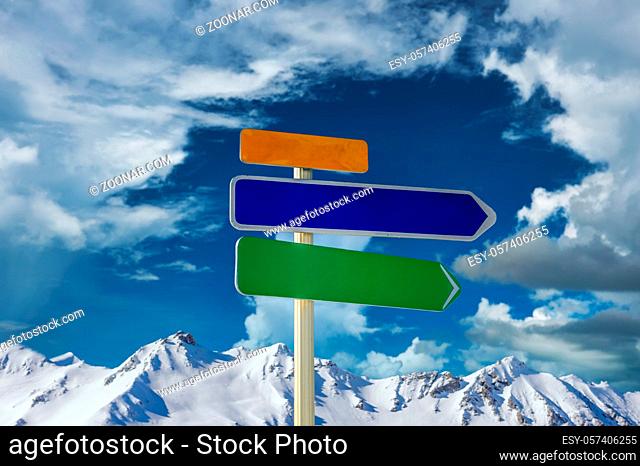 Alpine winter mountain landscape with arrow signs. French Alps covered with snow in sunny day. Val-d'Isere, Alps, France