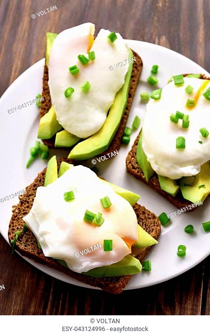 Healthy sandwiches with poached eggs and avocado on bread