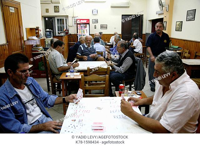 Men playing cards at a traditional men's cafe in Pothia, Kalymnos, Greece