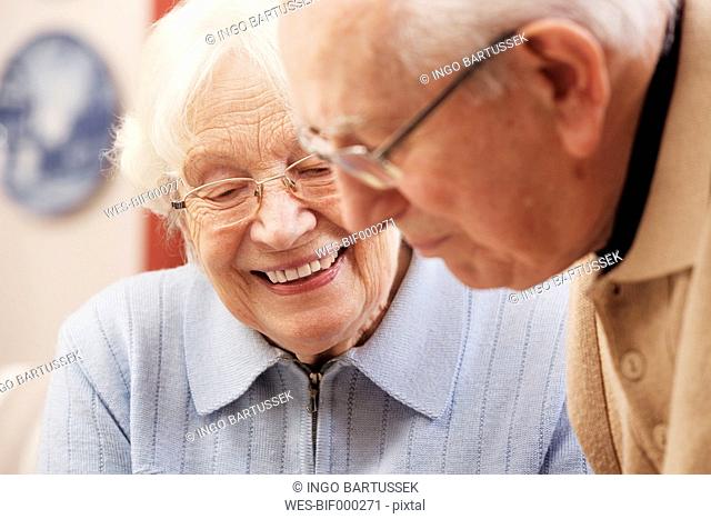 Senior couple watching old photographs at home
