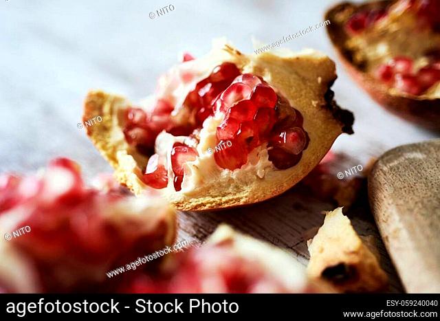 some pieces of a pomegranate fruit on a rustic wooden table