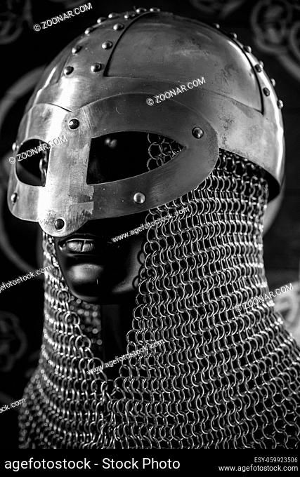 Soldier Viking helmet with chain mail of iron on red shield of wood and golden triskel