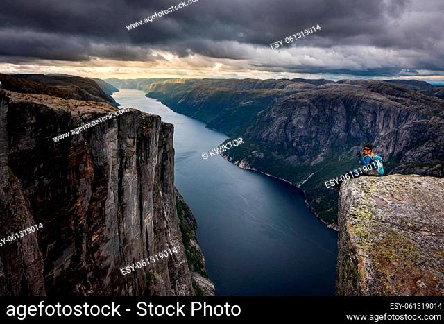 Backpacker sits on top of the Eagle Head Viewpoint near Kjeragbolten