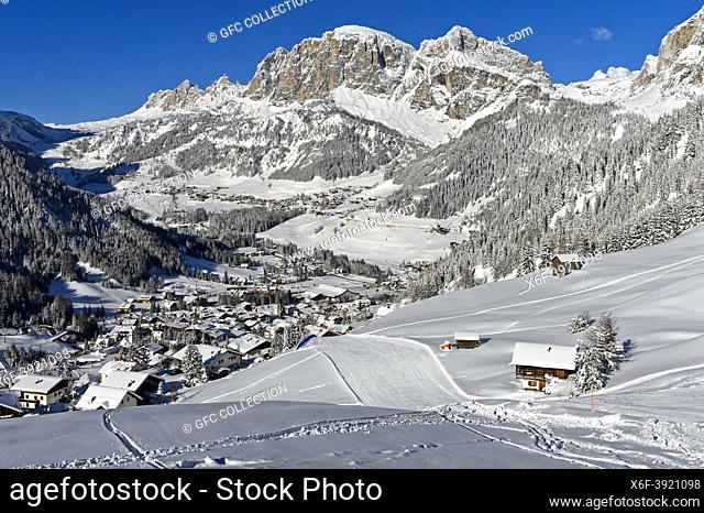 Empty ski slopes near the mountain village of La Villa in front of the snow-covered Dolomite peaks in the Alta Badia ski area, Dolomites, South Tyrol, Italy