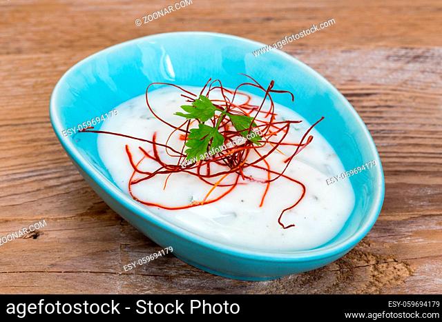 joghurt kräuter dip mit chilifäden auf holzhintergrund
