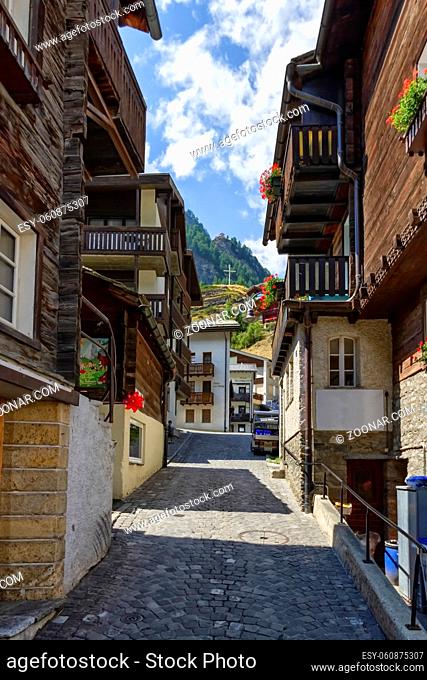 Street and typical wooden chalets in Zermatt village by day, Switzerland
