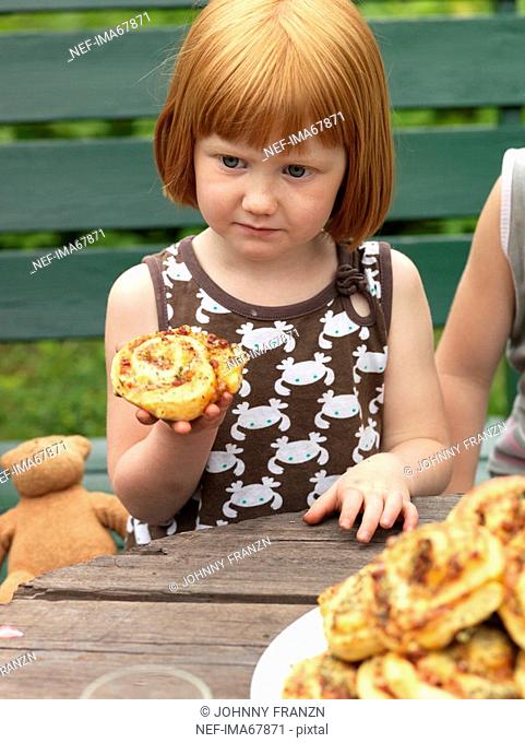 A girl eating a pizza bun