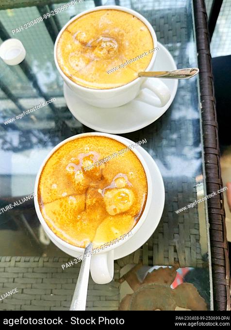 26 February 2023, Vietnam, Hanoi: Two cups of egg coffee (Egg coffee) stands on a table. The Vietnamese egg coffee was created in the 1940s rather out of...