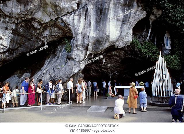 Pilgrims visiting the Our Lady of Lourdes statue in the cave at Massabielle, Lourdes, France