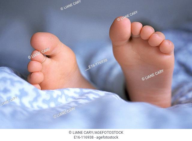 Feet of young girl sleeping on bed