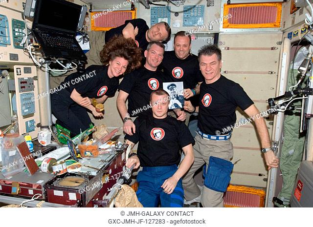 Expedition 27 crew members pose for a photo near the galley in the Zvezda Service Module of the International Space Station in honor of the 50th anniversary of...