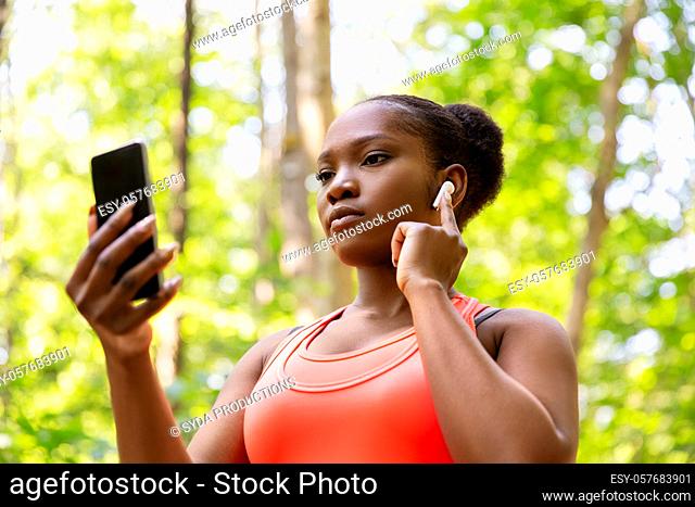 african american woman with earphones and phone