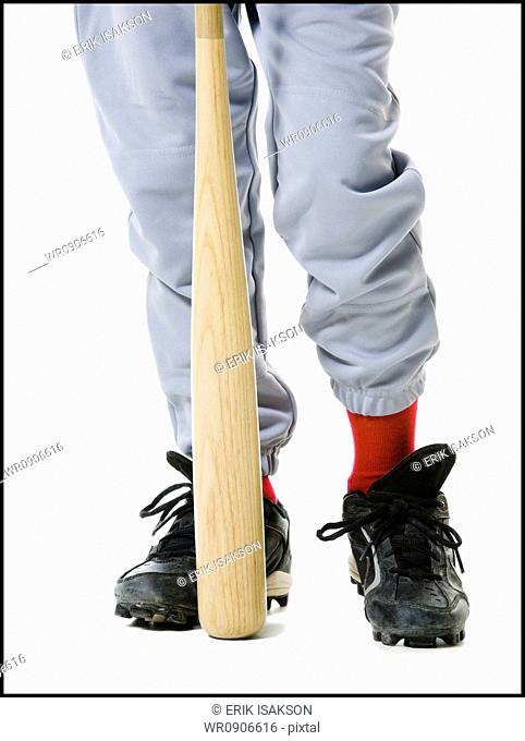 Low section view of a baseball player holding a baseball bat