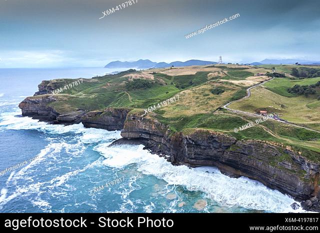 Aerial view of a coastal landscape with rocky cliffs and green meadows. Cantabria, Spain