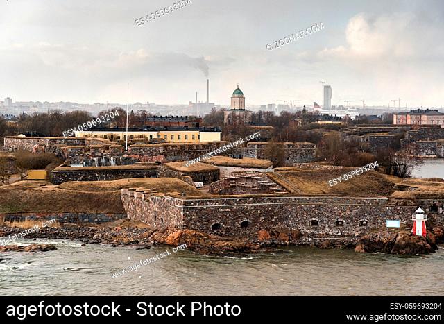 Suomenlinna fortress outside Helsinki on a spring day, with city in the background and a ferry, Finland