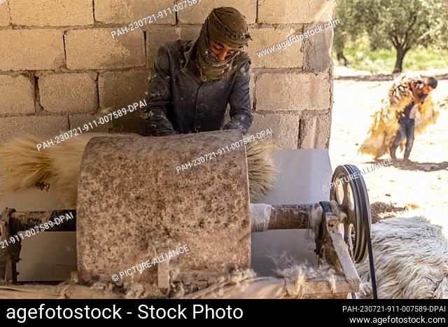 20 July 2023, Syria, Azmarin: Syrian workers process cattle hides at a workshop for tanning and natural leather production in the Syrian village of Azmarin