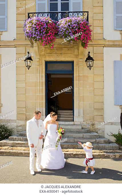 Bride, bridegroom and their daughter standing in front of the registrar's office