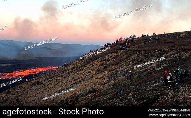 14 August 2022, Iceland, Reykjanes: After the volcanic eruption, onlookers make a pilgrimage to the fissure from which red lava continues to flow