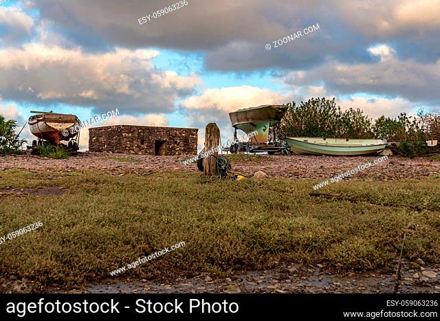 The pebble beach in Porlock Weir, Somerset, England, UK - with boats and an old bunker