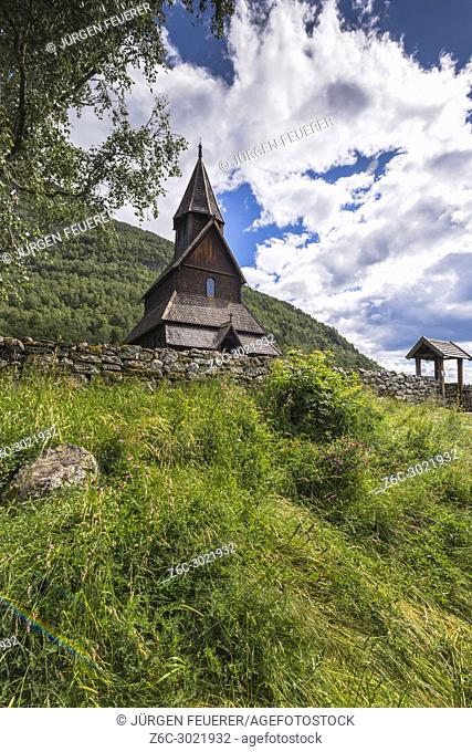Urnes Stave Church with flower meadow in green mountainscape, Ornes, Norway, World Heritage Site, Sognefjorden, Lustrafjorden