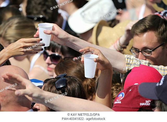 Invited guests wait for water in the blazing heat for the US President Barack Obama's speech front of Brandenburg Gate at Pariser Platz in Berlin, Germany