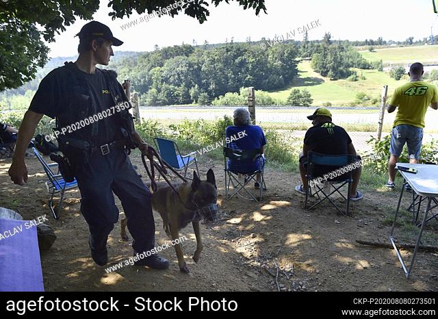People watch qualification for the Czech Road Motorcycling Grand Prix from behind the fence, in Brno, Czech Republic, on August 2020
