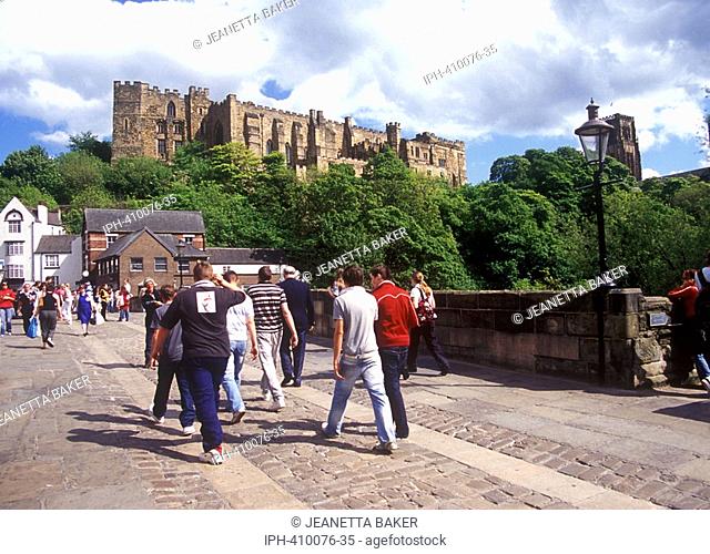 Durham - Visitors crossing Framwellgate Bridge over the River Wear with view showing the castle and cathedral