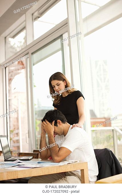 Smiling couple paying bills together
