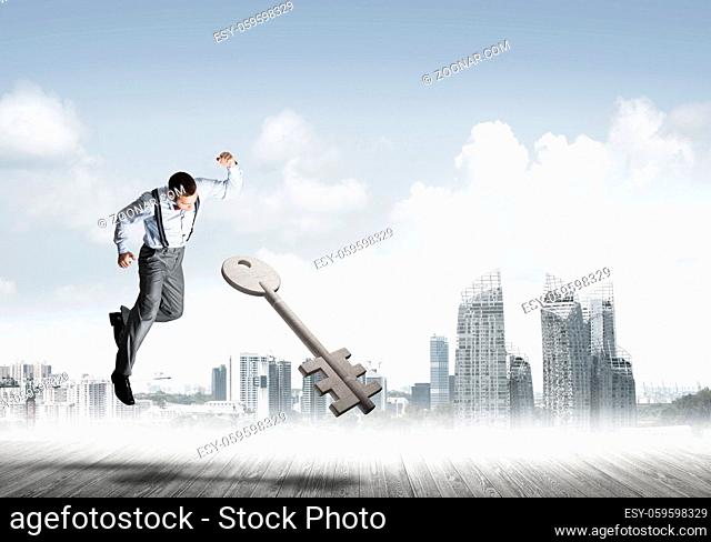 Determined businessman against modern cityscape breaking with fist stone key figure